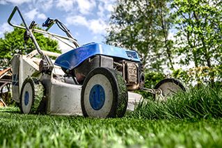 A lawn mower in the front yard.